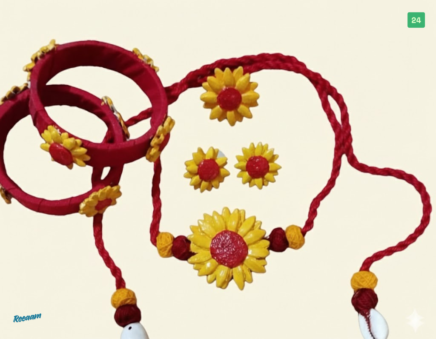 Bring a touch of sunshine to your look with this charming handmade floral jewellery set. Designed in a vibrant combination of deep red and bright yellow, each piece beautifully reflects warmth, joy, and traditional artistry.
The set features a stunning sunflower-inspired necklace with delicate threadwork, paired with matching earrings and handcrafted bangles that add a playful yet elegant finish. The soft texture and lightweight design make it comfortable for all-day wear, while the intricate floral detailing adds a graceful, festive appeal.
Perfect for cultural events, Haldi ceremonies, festive occasions, or even casual ethnic styling, this jewellery set effortlessly enhances your natural beauty with a fresh and lively charm.